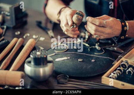 l'artigiano pulisce e lucida gli oggetti metallici. primo piano foto ritagliata Foto Stock