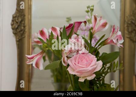 Un bouquet di fiori rosa diversi davanti a uno specchio Foto Stock