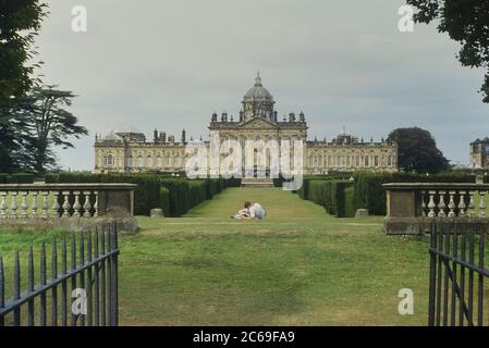 Una giovane coppia che giace sull'erba e si coccola, Castle Howard. Yorkshire, Inghilterra. REGNO UNITO Foto Stock