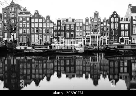 AMSTERDAM, PAESI BASSI - 16 FEBBRAIO 2016: Vista di edifici e barche lungo i canali di Amsterdam. Riflessi si possono vedere in acqua. Foto Stock