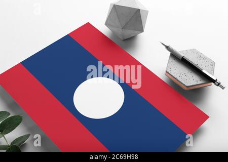 Bandiera Laos su sfondo minimalista. Lettera nazionale di invito con penna elegante su pietra. Concetto di comunicazione. Foto Stock