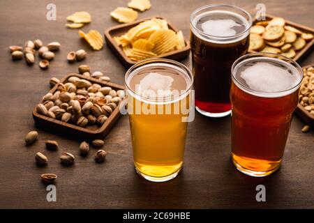 Tavolo per la compagnia di amici. Spuntini croccanti e diversi tipi di birra in bicchieri Foto Stock