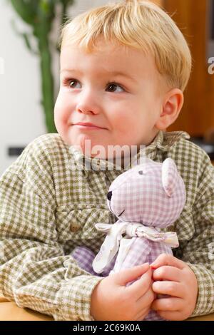 Ragazzo piccolo con giocattolo coccoloso, ritratto a mezza lunghezza, Germania Foto Stock