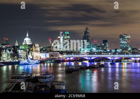 Parte dello skyline di Londra di notte che mostra gli edifici nel centro di Londra e il Tamigi Foto Stock