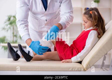 Piccola ragazza che visita giovane medico Foto Stock