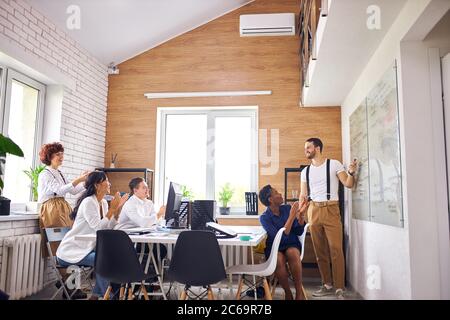 Pubblico multietnico, gruppo internazionale di ascoltatori applaudono a un buon pubblico parlare di giovane Foto Stock