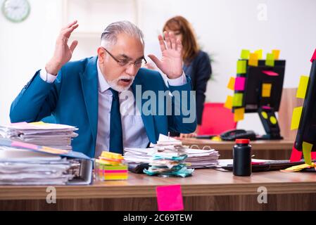 Due dipendenti e lavoro eccessivo in ufficio Foto Stock