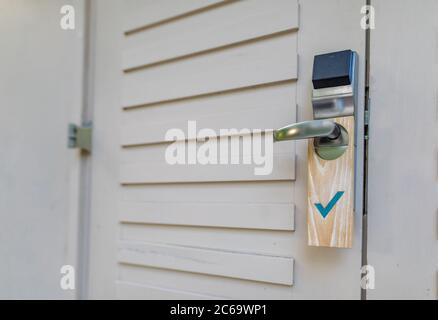 La porta della camera dell'hotel con un cartello che indica che la porta è pulita Foto Stock