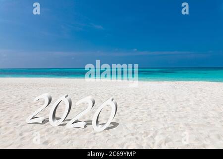 Felice anno nuovo 2020 sta venendo concetto di sabbia tropicale spiaggia caratteri oceano. Esotica celebrazione del nuovo anno Concept image. Foto Stock