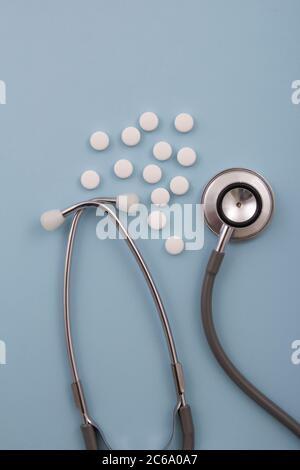 Vista dall'alto di pillole e capsule all'esterno della confezione accanto all'apparecchiatura e ai dispositivi medici. Foto Stock