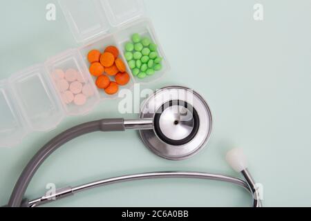 Vista dall'alto di pillole e capsule all'esterno della confezione accanto all'apparecchiatura e ai dispositivi medici. Foto Stock