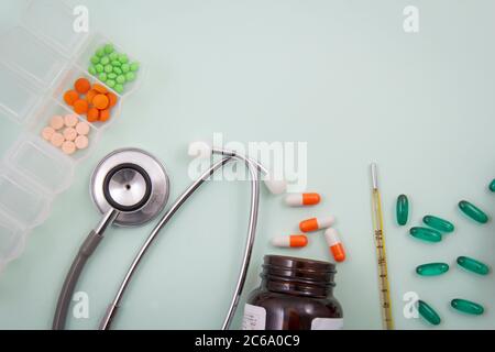 Pillole e capsule colorate all'esterno della confezione all'interno del contenitore in vetro della confezione. Foto Stock