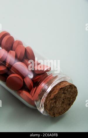 Pillole e capsule colorate all'esterno della confezione all'interno del contenitore in vetro della confezione. Foto Stock