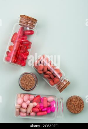 Pillole e capsule colorate all'esterno della confezione all'interno del contenitore in vetro della confezione. Foto Stock