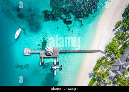 Atolli e isole nelle Maldive con molo e ville sull'acqua. Vacanza estiva di lusso, sabbia bianca, mare blu, idilliaca spiaggia tropicale isola Foto Stock