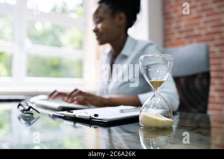 Black Accountant Woman lavora con fattura e clessidra Foto Stock