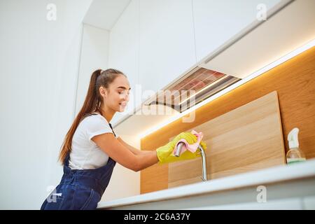 Pulizia perfetta da giovane donna janitor, servizio di pulizia. Attento, professionale ordinato fare il suo lavoro con piacere, società di pulizia Foto Stock