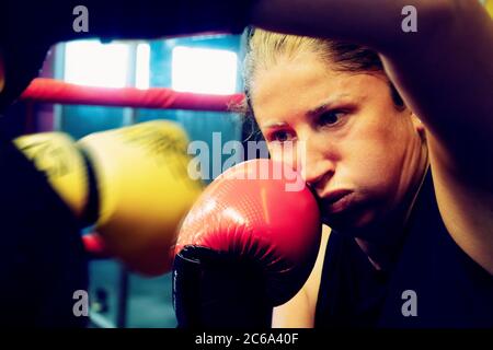 Giovane donna e il suo personal trainer che lavorano su kickbox per una vita sana e una difesa di sé. Foto Stock