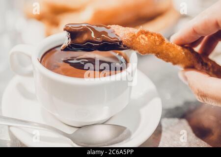 Churros con cioccolata calda per colazione - deliziosi dolci alla crema pasticcera spagnola - concentrazione selettiva Foto Stock