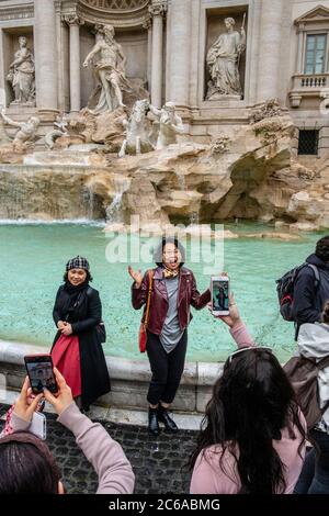 Turisti che scattano fotografie alla Fontana di Trevi, Roma, Italia Foto Stock