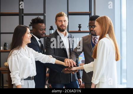 Colleghi di lavoro amichevoli insieme lavorano come team in ufficio, sorridere . Concetto di persone di affari Foto Stock