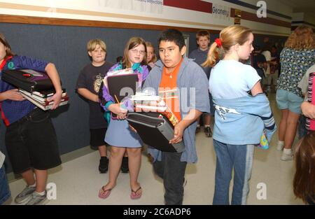 Gun Barrel City, Texas 9 settembre 2003: Gli studenti della quinta elementare lottano con un sacco di libri e materiale didattico tra le classi. Gli zaini sono usati solo in homeroom a causa di problemi di spazio nelle aule di quinta elementare. ©Bob Daemmrich Foto Stock