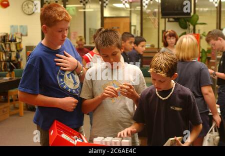 Mabank, Texas USA, 10 settembre 2003: Ragazzi delle scuole medie, che mostrano una varietà di dimensioni e altezze del corpo, guardano una collezione di carte nella loro biblioteca scolastica. Nessuna pubblicazione ©Bob Daemmrich Foto Stock