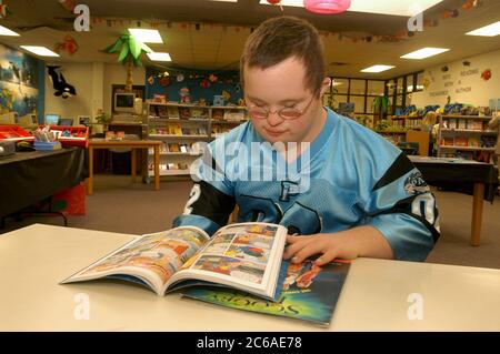 Mabank, Texas USA, 10 settembre 2003: Tredicenne con sindrome di Down nella sua biblioteca della scuola media, guardando graphic novel. SIG. SP75 ©Bob Daemmrich Foto Stock