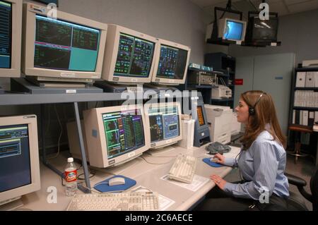 Houston Texas USA, 18 settembre 2003: Ingegnere informatico femminile che indossa cuffie lavora nella sala di controllo per il simulatore di salita/entrata basato sul movimento per lo Space Shuttle, dove gli addestratori mettono in atto scenari di missione per astronauti in addestramento. ©Bob Daemmrich Foto Stock