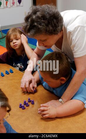 Mabank, Texas 10 settembre 2003: Conteggio in coppia. VERSIONE MODELLO SP-79. Aiuto dell'insegnante nella classe di abilità di vita che insegna un ragazzo con disabilità intellettuali a contare. ©Bob Daemmrich Foto Stock