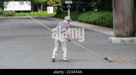 Lavoratori pulizia del tempio santuario Meiji Jingu terra, Tokyo, Giappone Foto Stock