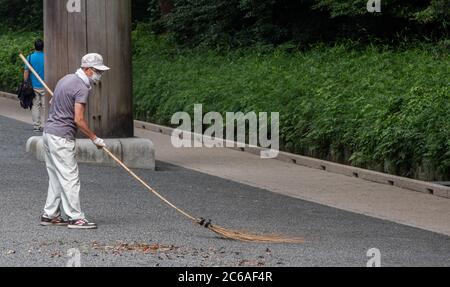 Lavoratori pulizia del tempio santuario Meiji Jingu terra, Tokyo, Giappone Foto Stock