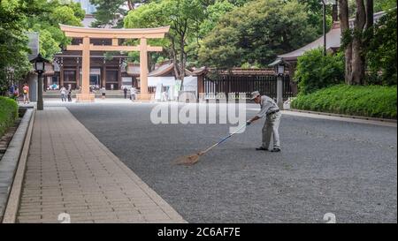 Lavoratori pulizia del tempio santuario Meiji Jingu terra, Tokyo, Giappone Foto Stock