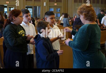 Austin, Texas USA, dicembre 2003: Comunione in santuario durante la messa per gli scolari a St. Ignatius Martyr Catholic Parish a Natale. ©Bob Daemmrich Foto Stock