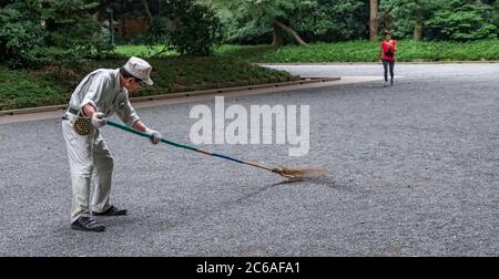 Lavoratori pulizia del tempio santuario Meiji Jingu terra, Tokyo, Giappone Foto Stock