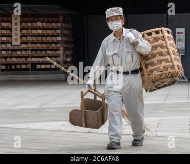 Lavoratori pulizia del tempio santuario Meiji Jingu terra, Tokyo, Giappone Foto Stock