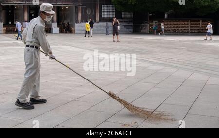 Lavoratori pulizia del tempio santuario Meiji Jingu terra, Tokyo, Giappone Foto Stock