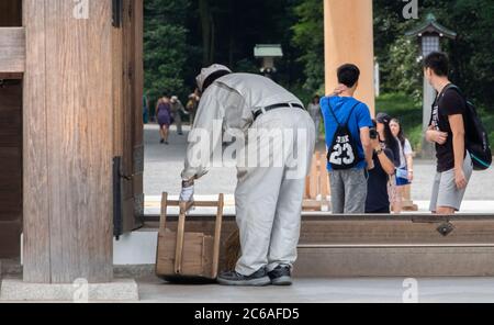 Lavoratori pulizia del tempio santuario Meiji Jingu terra, Tokyo, Giappone Foto Stock