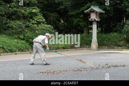 Lavoratori pulizia del tempio santuario Meiji Jingu terra, Tokyo, Giappone Foto Stock