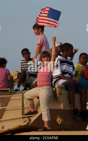 Killeen, Texas, 22 aprile 2004: Festa di benvenuto a casa per gli Stati Uniti La 4th Infantry Division dell'esercito torna dall'Iraq alla sua base di Fort Hood, una vasta base militare nel Texas centrale. Madelyn Vescovo di Killeen, tenendo in alto una bandiera americana, celebra il ritorno di sua madre dall'Iraq. ©Bob Daemmrich Foto Stock