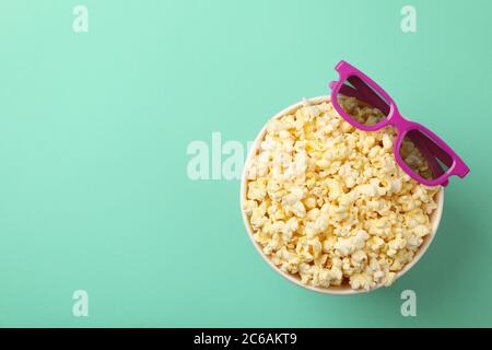 Secchio con popcorn e bicchieri 3d su sfondo di menta Foto Stock