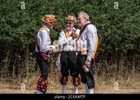 Tre ballerini Morris chiacchierano bevendo e socializzano tra le danze. Warwickshire Inghilterra Regno Unito Foto Stock