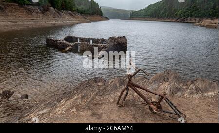 Lyn Brianne serbatoio durante una siccità e rivelando una casa che è stata coperta quando la valle è stata allagata. Carmathenshire Galles Foto Stock
