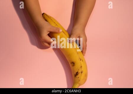 Brutto banana in mani di bambini. Cibo brutto tendenza, copia spazio Foto Stock