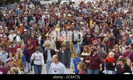 Austin, Texas USA, novembre 26 2004: I tifosi della Texas A&M University portano il retro della tradizionale parata su Congress Avenue, con l'A&M Corps of Cadets e la banda di marcia, prima della partita di football universitario A&M-Texas. ©Bob Daemmrich Foto Stock