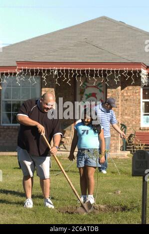 Monte alto, Texas USA, 11 dicembre 2004: La famiglia Villalpando lavora nel cortile della loro modesta casa con tre camere da letto, un bagno finanziato da Proyecto Azteca, un programma di assistenza abitativa che richiede alle famiglie di contribuire volontariamente in cambio dell'acquisto di una casa a basso costo. Modello rilasciato ©Bob Daemmrich Foto Stock