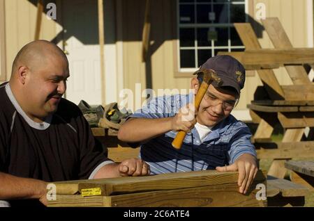 San Juan, Texas USA, 17 dicembre 2004: Padre ispanico e figlio di 15 anni si offrono volontari per lavorare sulle scale per una nuova casa in un progetto di alloggi a basso reddito. La famiglia acquistò una casa attraverso Proyecto Azteca, un programma di assistenza abitativa in cui le famiglie contribuiscono ore di volontariato in cambio dell'aiuto di Proyecto Azteca nel finanziamento dell'acquisto di una casa. Modello rilasciato. ©Bob Daemmrich Foto Stock