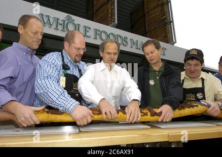 Austin, Texas USA, 3 marzo 2005: Inaugurazione del nuovo 000 flagship store Whole Foods di 80 metri quadrati e della sede centrale nel quartiere del mercato del centro di Austin. Da sinistra a destra ci sono i dirigenti di Whole Foods Walter Robb, Seth Stutzman, Jim Sud, John Mackey, e Bruce Silverman, partecipare alla tradizionale cerimonia di affettatura del pane al posto del taglio del nastro. ©Bob Daemmrich Foto Stock