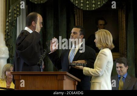 Austin, Texas USA, 11 marzo 2005: L'assistente del segretario di Stato del Texas Buddy Garcia (centro) presta giuramento dal giudice capo della Corte suprema del Texas Wallace Jefferson (a sinistra) nella camera del Senato del Texas. Texas Gov. Rick Perry è seduto all'estrema destra. ©Bob Daemmrich Foto Stock