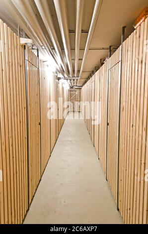 Corridoio in una cantina con unità di stoccaggio in legno Foto Stock